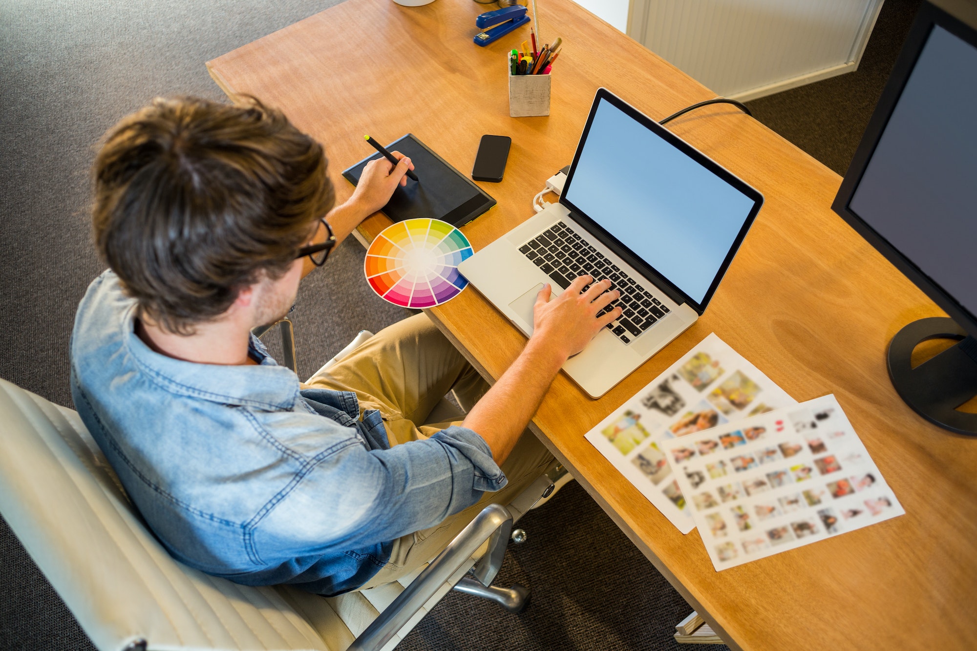 Designer working with colour wheel and digitizer in the office